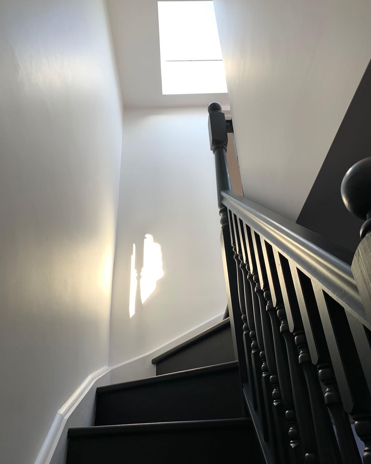 Black painted staircase rising to the loft under a roof light, Victorian house Hanwell W7