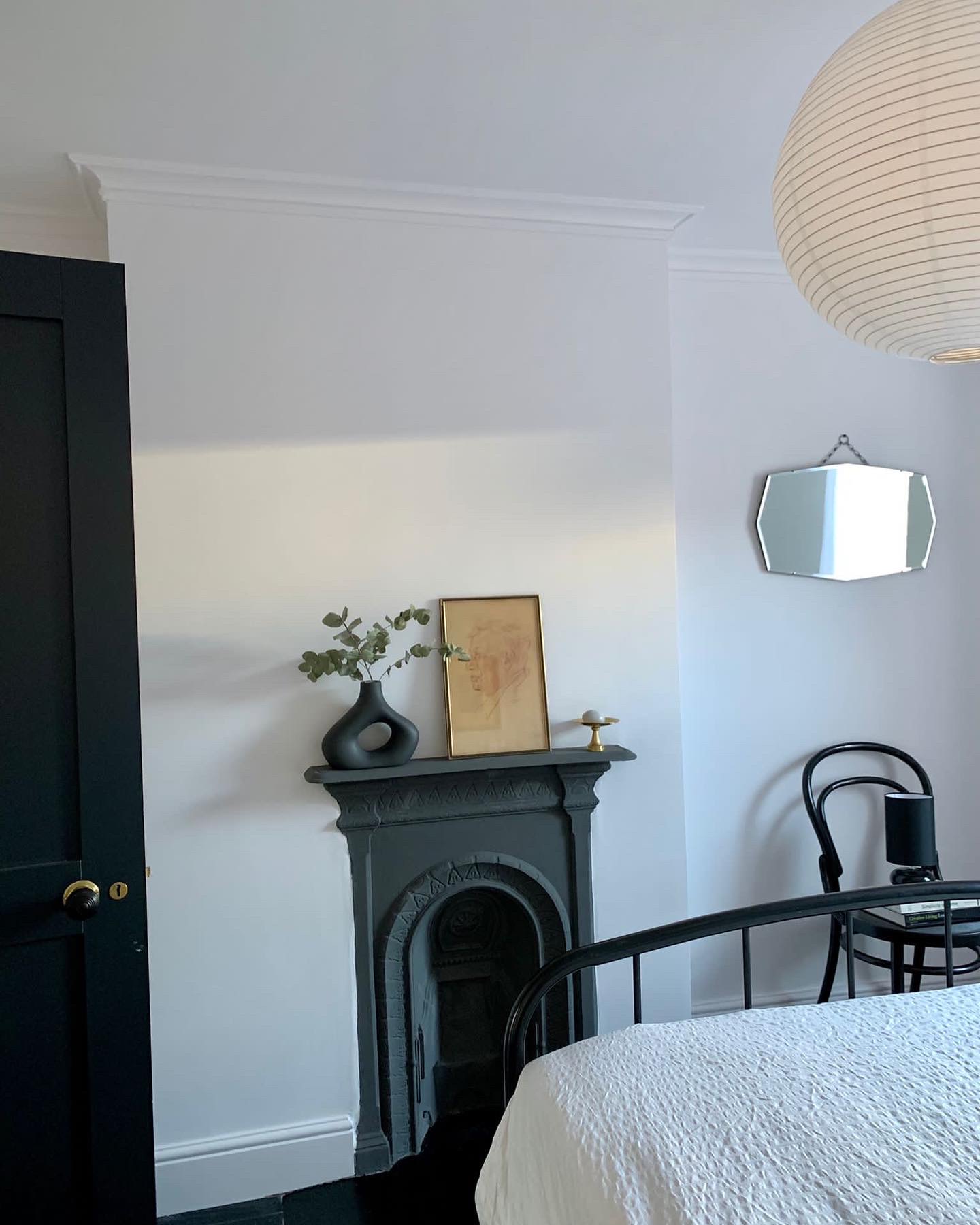 Bedroom with restored cast iron fireplace and black framed mirror, Clairville Gardens W7