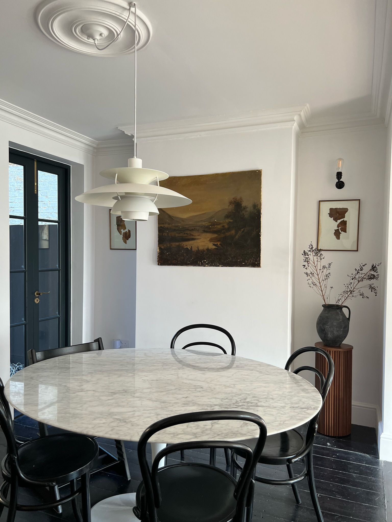 Dining room with round marble table, bentwood chairs and globe pendant in a Victorian house, Hanwell W7