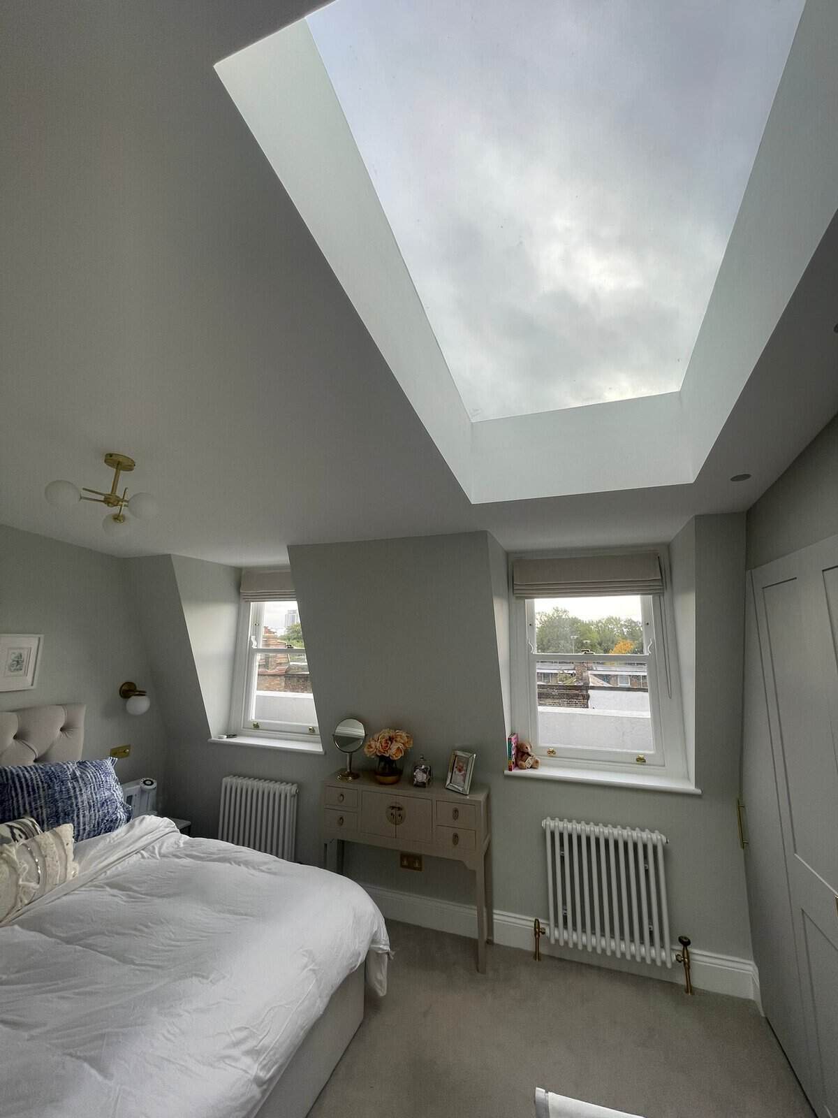 Loft bedroom under a large roof light with dormer windows, N4 loft conversion