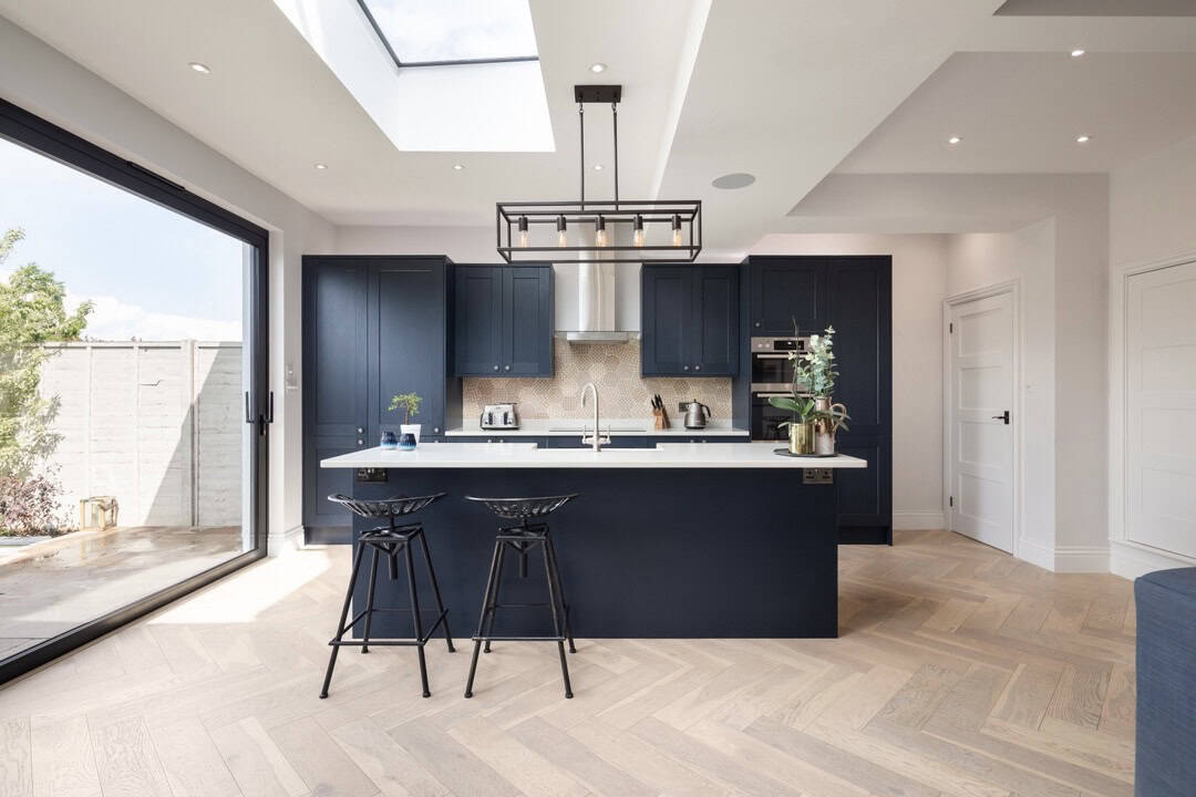 Navy kitchen with island, roof lights, herringbone floor and sliding glass door, Highbury N5
