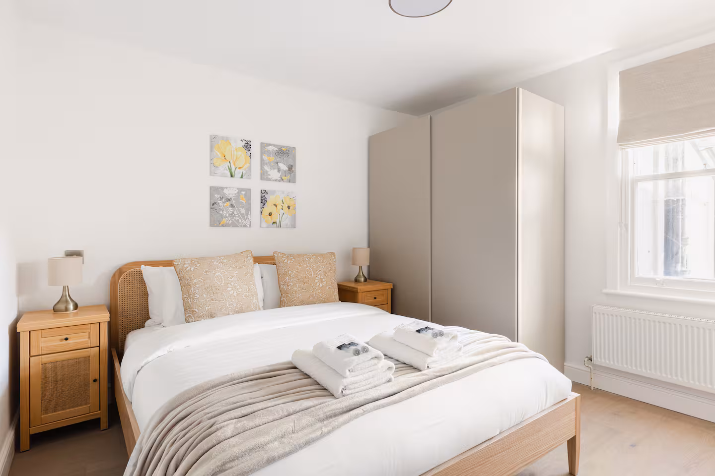 Bedroom with oak bedside tables and tall fitted wardrobe, St John's Wood renovation