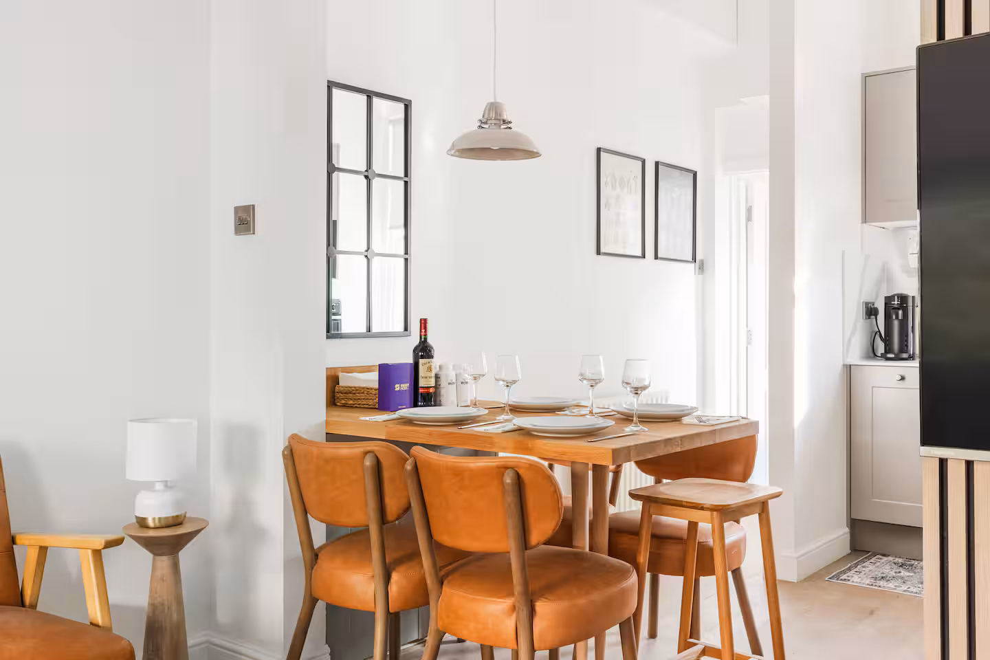 Dining table and tan leather chairs with black framed mirror, Allitsen Road NW8