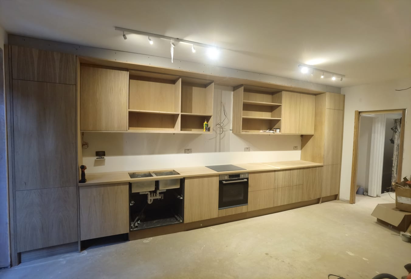 Wide view of oak kitchen run with integrated appliances in a Chiswick kitchen renovation