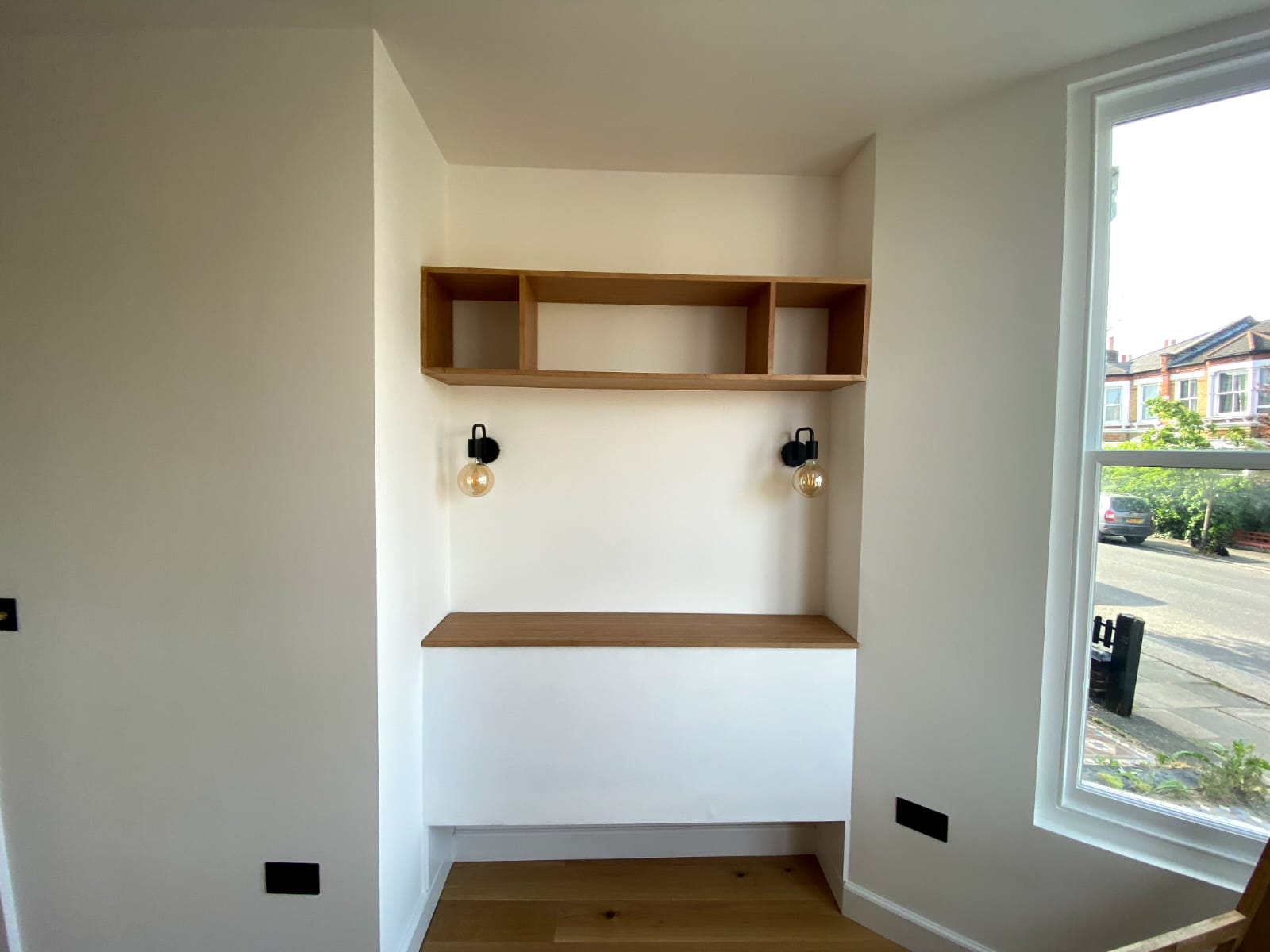 Built in oak desk and floating shelves in a window alcove study nook, Chiswick W4