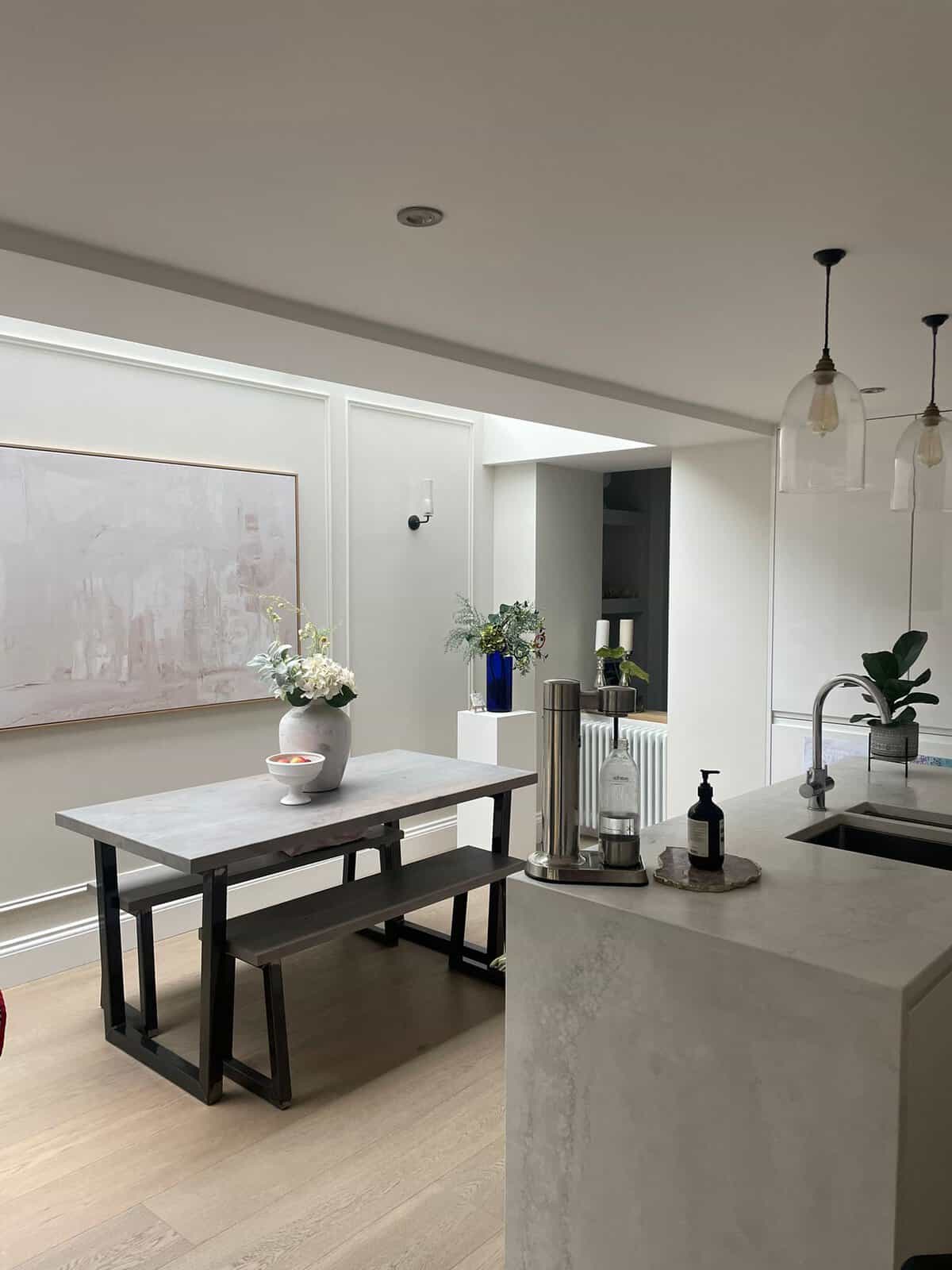 Dining table under a roof light beside a marble effect kitchen island, rear extension N4